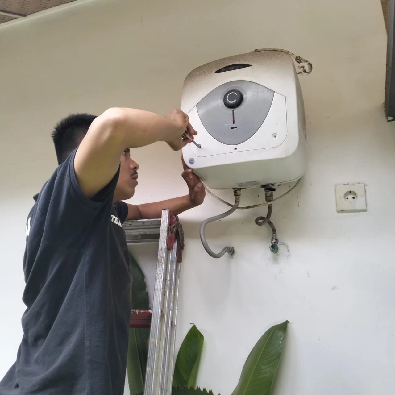 Perbaikan thermostat water heater di rumah keluarga Medan Baru, teknisi menggunakan alat ukur profesional